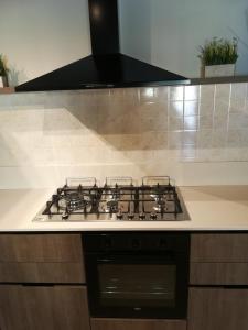 a stove top with a black hood in a kitchen at Casa Lorena in Desenzano del Garda