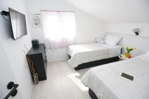 a white room with two beds and a window at Split Old Town Apartment in Split