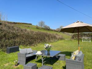 a table with an umbrella and two chairs and a table with at Diana's Cottage in Braunton