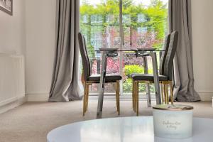 a table and chairs in front of a window at 3Bed Coventry Gem - The Perfect Home Away From Home in Coventry