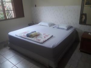 a large bed in a bedroom with a white bedspread at Casa das Flores in Chapada dos Guimarães