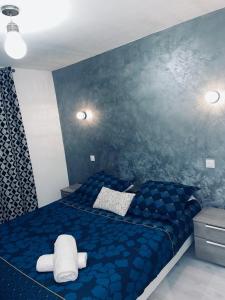- une chambre dotée d'un lit bleu avec un animal rembourré dans l'établissement Le 56, à Annecy