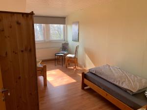 a bedroom with a bed and a desk and a chair at Ferienwohnung Buchenblick in Kassel