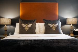 a bedroom with a bed with pillows with bees on them at The Arran Suite - Your Stylish Scottish Getaway! in Glasgow
