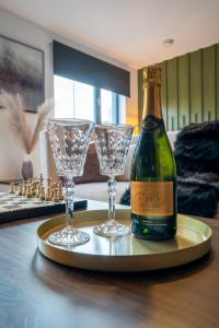 Una botella de champán y dos copas en una bandeja. en The Arran Suite - Your Stylish Scottish Getaway! en Glasgow