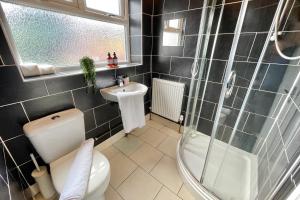 a bathroom with a toilet and a sink and a shower at Tranquil 3Bed Retreat - Walk to Coventry University, Fargo Village & Coventry City Centre in Coventry