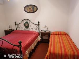 サトゥルニアにあるPiane Del Bagnoのベッドルーム1室(ベッド1台、テーブル、壁の絵付)