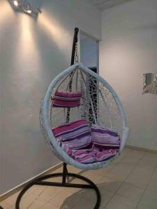 a hanging basket filled with purple towels in a room at HOMESTAY DELISHA PARIT RAJA UTHM in Parit Raja