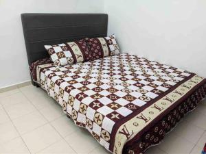 a bed with a quilt and pillows on it at HOMESTAY DELISHA PARIT RAJA UTHM in Parit Raja