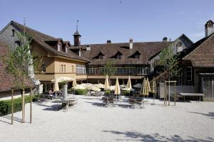 einen Innenhof mit Tischen und Stühlen in einem Gebäude in der Unterkunft Klosterhotel St. Petersinsel in Sankt Petersinsel