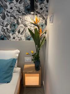 a room with a bed and a vase with a plant in it at Sapore Di Sale Accommodation Tropea in Tropea