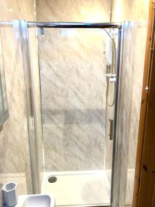 a shower with a glass door in a bathroom at Tar Top in Silsden