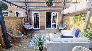 un patio con sofá y sillas en una terraza en Beautiful 2bed house with garden, walking distance to town - FREE parking, en Glasgow
