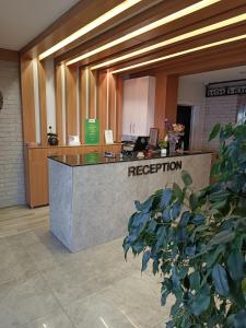 a reception desk in a lobby with a tree at Airport Trabzon Otel in Bostancı