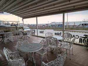 un patio con mesas y sillas en un barco en Airport Trabzon Otel, en Bostancı