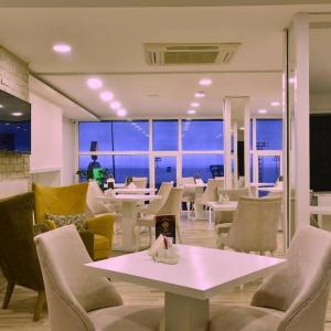 restauracja ze stołami i krzesłami oraz widokiem na ocean w obiekcie Airport Trabzon Otel w mieście Bostancı