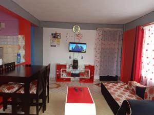 uma sala de estar com um sofá e uma mesa em Megs Place - Red - Embu Town em Embu