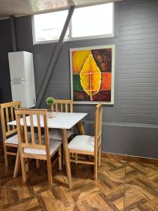 Un comedor con una mesa y sillas y un cuadro. en 302 Bonito Apartamento para 3 Excelente precio y ubicacion, en Ibagué 31 fotos más