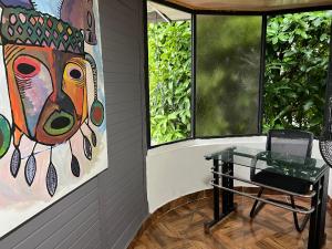 una habitación con una mesa de cristal y una pintura en 302 Bonito Apartamento para 3 Excelente precio y ubicacion, en Ibagué