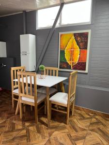 Un comedor con una mesa y sillas y un cuadro. en 302 Bonito Apartamento para 3 Excelente precio y ubicacion, en Ibagué