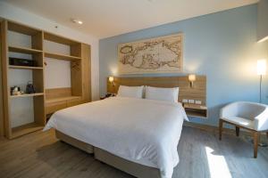 a bedroom with a large white bed and a chair at Holiday Inn Express Cartagena Manga by IHG in Cartagena de Indias
