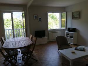 un soggiorno con tavolo, sedie e TV di Appartement Saint-Malo 800m de la plage a Saint Malo
