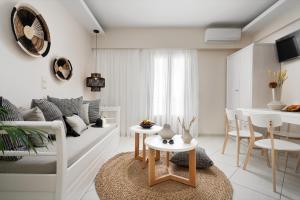 a white living room with a couch and a table at Ormos Holiday Studios in Naxos Chora