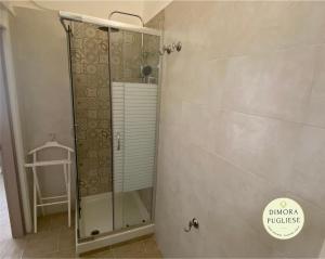 La salle de bains est pourvue d'une douche avec une porte en verre. dans l'établissement Dimora Pugliese, à Palo del Colle