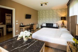 a bedroom with a large white bed and a desk at Podere del Priorato in Albinia