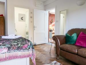 un soggiorno con divano in pelle e porta di Farriers Retreat a Budleigh Salterton