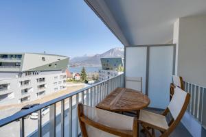 einen Balkon mit 2 Stühlen und Blick auf das Wasser in der Unterkunft La Cantonade - Nice T2 with garage for 4 people near Beach in Annecy + 12 Fotos