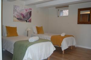 シャルネ・レ・マコンにあるLa Maison de Marieの白い壁の客室内のベッド2台