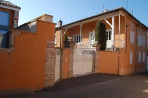ein orangefarbenes Haus mit einem Tor und einem Zaun in der Unterkunft La Maison de Marie in Charnay-lès-Mâcon