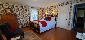 um quarto com uma cama e papel de parede floral em Blackberry Inn em Camden