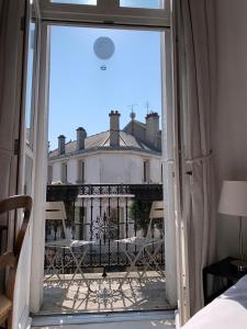 une fenêtre ouverte avec vue sur un bâtiment dans l'établissement Le Saint-Rémy, à Épernay