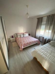 a bedroom with a bed with a pink comforter at Villa Nina Poreč in Poreč