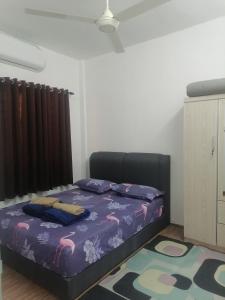 ein Schlafzimmer mit einem Bett mit einer lila Bettdecke in der Unterkunft Selesa Inn Homestay in Nilai