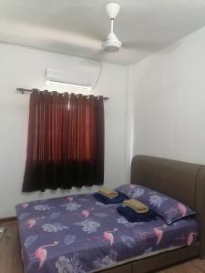 ニライにあるSelesa Inn Homestayの小さなベッドルーム(紫色のベッドカバー付)