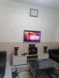 ein Wohnzimmer mit einem TV und einem Tisch in der Unterkunft Selesa Inn Homestay in Nilai