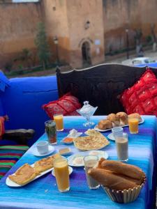 una mesa azul con comida y bebidas. en Hotel Al kassaba en Xauen