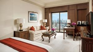 a hotel room with a bed and a couch and a desk at The Peninsula Bangkok - SHA Extra Plus in Bangkok
