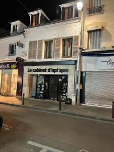 a store on the side of a street at night at Charmant 2 pièces in Poissy