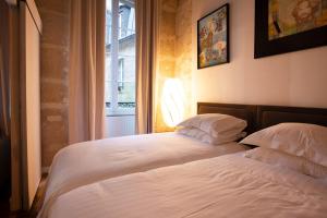 1 dormitorio con 2 camas y ventana en High Stay Saint Germain de Pres Paris 6, en París