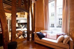 sala de estar con sofá y ventana grande en High Stay Saint Germain de Pres Paris 6, en París