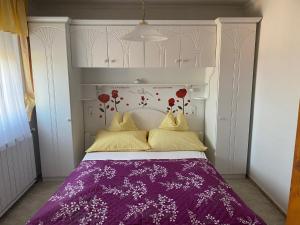 ザラカロシュにあるArany Apartmanház Zalagyöngyeのベッドルーム(紫の毛布付きのベッド1台付)