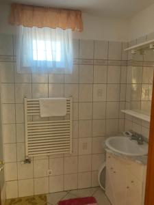 łazienka z umywalką, toaletą i oknem w obiekcie Arany Apartmanház Zalagyöngye w Zalakaros +15 zdjęć