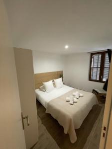 Un dormitorio con una gran cama blanca con velas. en Cassis Loc - Appartement meublé en Cassis