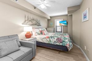 een slaapkamer met een bed en een bank bij Harbor Place 313 Beach Front Gulf View in Gulf Shores