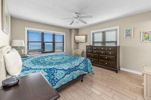 a bedroom with a bed and a dresser and windows at Harbour Place 313 in Gulf Shores
