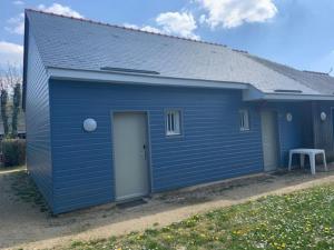 un hangar bleu avec une porte dans une cour dans l'établissement Cottage 102, à Saumur